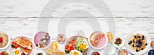 Healthy breakfast or brunch bottom border on a white wood banner background. Top view.