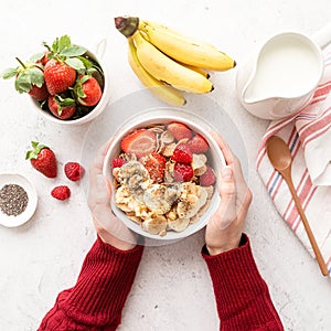 Healthy breakfast, cereal, fresh berries and milk in a bowl, top view