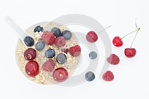 Healthy breakfast cereal oat flakes in white bowl, top view