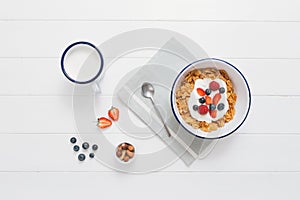 Healthy breakfast with cereals and berries in an enamel bowl