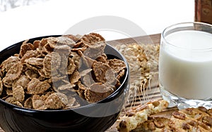 A healthy breakfast. Cereals are at the black plate on the wood background photo
