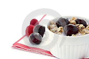 Healthy Breakfast with Cereals, Yogurt, Cherries and Raspberries in White Bowl