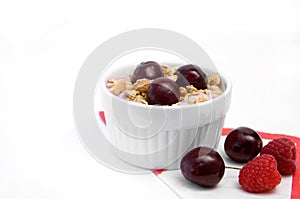 Healthy Breakfast with Cereals, Yogurt, Cherries and Raspberries in White Bowl