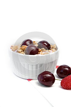 Healthy Breakfast with Cereals, Yogurt, Cherries and Raspberries in White Bowl