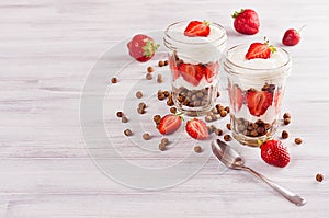Healthy breakfast with chocolate balls corn flakes, sliced strawberry on white wood board.