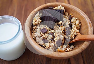 Healthy breakfast - chocolate muesli in wooden bowl with fresh milk. Spain