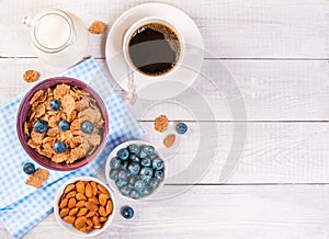 Healthy breakfast, coffee cornflakes berries and milk, with text space top view close-up