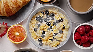 Healthy breakfast concept with corn flakes and fresh berries on white table