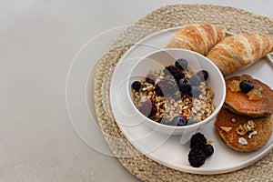 Healthy breakfast concept. Granola with berries, croissants and