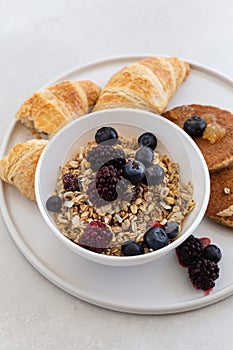 Healthy breakfast concept. Granola with berries and croissants.