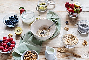 Healthy breakfast concept with oat flakes, fruits, yogurt, nuts, berries, chia seeds