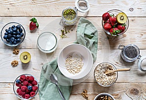 Healthy breakfast concept with oat flakes, fruits, yogurt, nuts, berries, chia seeds