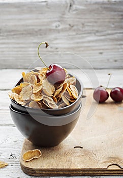 Healthy breakfast concept: whole-grain cereals with berries in ceramic bowls on a wooden light background. Selective