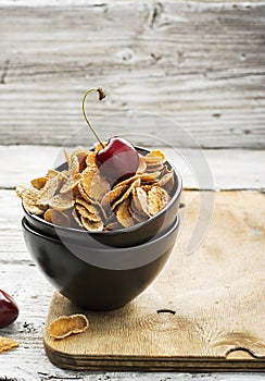 Healthy breakfast concept: whole-grain cereals with berries in ceramic bowls on a wooden light background. Selective