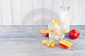 Healthy breakfast with corn flakes, slice peach and milk bottle on white wood board. Decorative border with copy space.