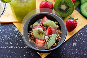 Healthy breakfast: crispy muesli with fresh strawberries and kiwis in close-up