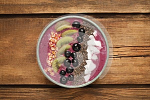 Healthy breakfast with delicious acai smoothie and fruits in bowl on wooden table, top view