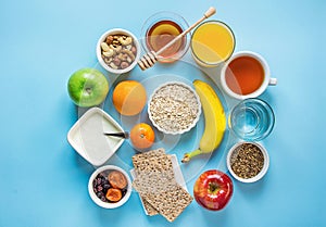 Healthy Breakfast Fiber Sources Digestion Oatmeal Honey Fruits Apples Banana Orange Juice Water Green Tea Nuts. Light Blue Table