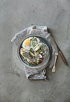 Breakfast with avocado toast, fried egg and salad, copy space