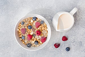 Healthy breakfast. Fresh granola, muesli with yogurt and berries on grey background. Copy space