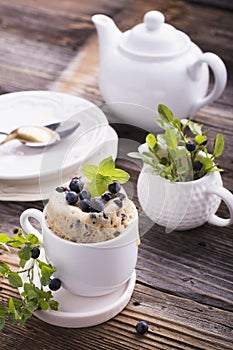 Healthy breakfast. Fresh homemade mug cake with forest blueberries in a white ceramic bowl sprig of ripe berries on the