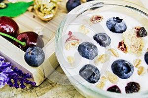 Healthy breakfast with Fresh yogurt, granola and muesli with  cherry and berries in small glass on Wooden tray, Food concept for