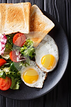 Healthy breakfast of fried eggs with fresh vegetable salad and t