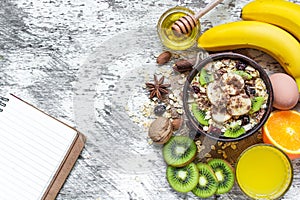 Healthy breakfast with fruit oatmeal and blank notebook