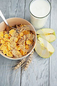 Healthy breakfast with glass of milk, apple and corn flakes
