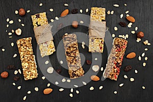 Healthy Breakfast-granola bars with berries and nuts on a dark wooden background.