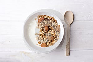 Healthy breakfast granola with greek yogurt, honey, mix nuts on white wooden background top view, copy space