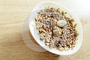 Healthy breakfast. Greek style yogurt with granola in a white bowl on a wooden table