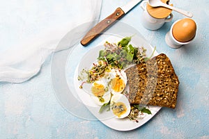 Healthy breakfast: Hard boiled eggs, fresh radish sprouts, arugula and dark whole wheat bread