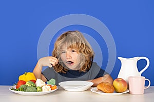 Healthy breakfast lunch for kids. Little kid boy have a dinner. Hungry face and enjoy eating enjoy food concept. Child