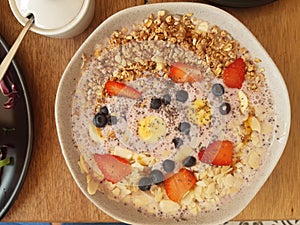 Healthy breakfast made of plain yogurt, fresh fruits, dried fruits and cereals.