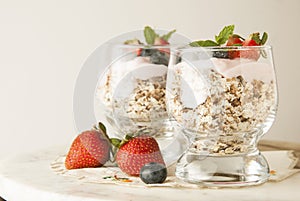 Healthy breakfast, oat meal with fruits: bluebery, strawbery and min, parfait in a glass on a rustic background. Healthy food.