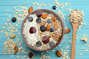 healthy breakfast. oatmeal, blueberries, raspberries and nuts on blue wooden table. Top view with copy space