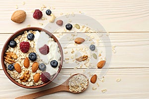 healthy breakfast. oatmeal, blueberries, raspberries and nuts on white wooden table. Top view with copy space