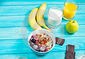 Healthy Breakfast - Oatmeal with fruits, milk and juice at blue table