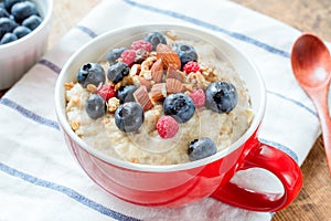 Healthy breakfast with oatmeal porridge, fresh berries and nuts