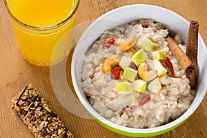 Healthy breakfast, oatmeal porridge with fruits, nuts and juice