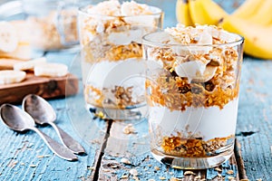 Healthy breakfast parfait. homemade granola with natural yogurt, banana and caramel sauce