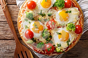 Healthy breakfast pizza with eggs, broccoli, tomatoes and parsley close-up. horizontal top view