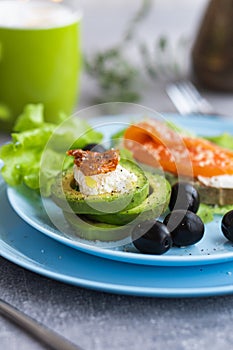 Healthy breakfast. Sandwich with smoked salmon, avocado cheese on lettuce salad leaves and coffee