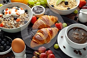 Healthy Breakfast served with coffee, orange juice, croissants, egg, cereals, oatmeal and fruits.