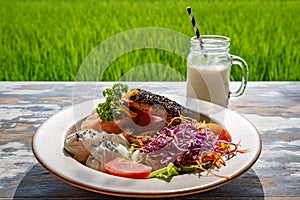 Healthy breakfast served on a vintage table with an emerald green rice field background. Concept of a healthy food and healthy