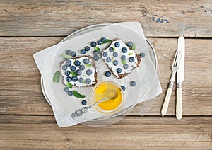 Healthy breakfast set with ricotta, fresh blueberries, honey and