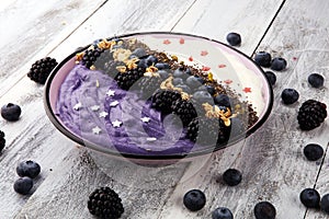 Healthy breakfast. smoothie bowl with blackberries and granola on rustic background