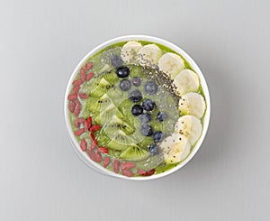 Healthy breakfast smoothie bowl topped with blueberry, kiwi, banana, spinach, Chia seeds and Goji berries. Detox concept.