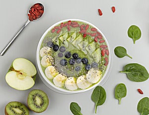 Healthy breakfast smoothie bowl topped with blueberry, kiwi, banana, spinach, Chia seeds and Goji berries. Detox concept.
